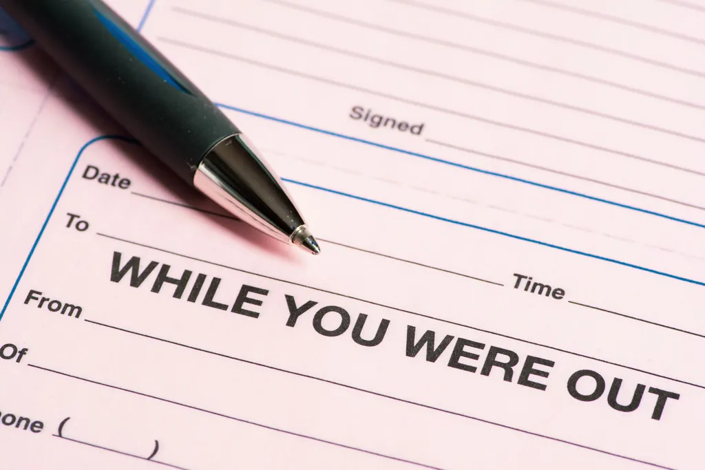 A pink While You Were Out phone message slip and a pen, a call taken as a message instead of a booked job